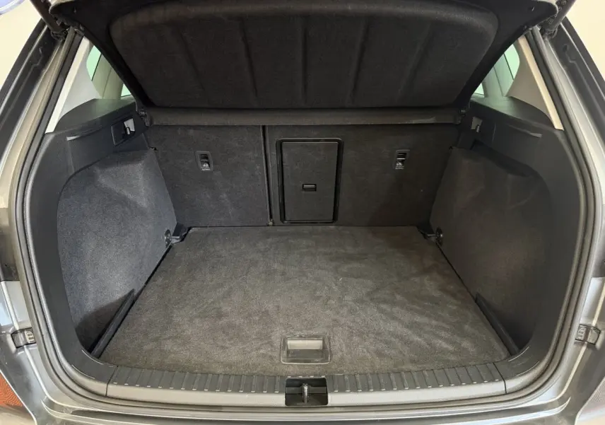 Coffre ouvert gris clair du SEAT Ateca 2023, vue arrière montrant un espace de chargement propre et spacieux.