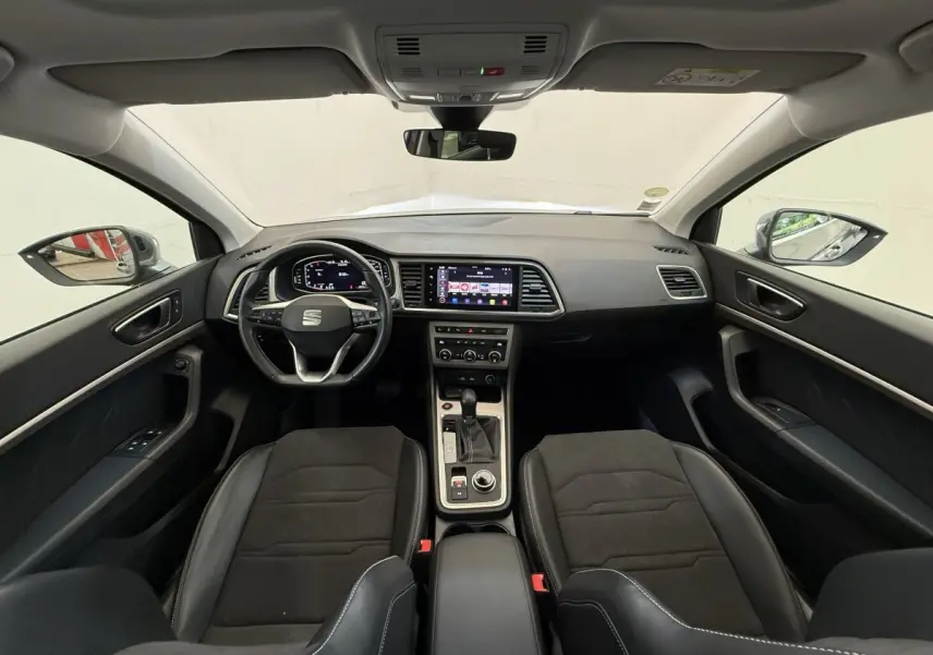 Vue intérieure avant du SEAT Ateca 2023 avec tableau de bord moderne et sièges noirs en alcantara et cuir.