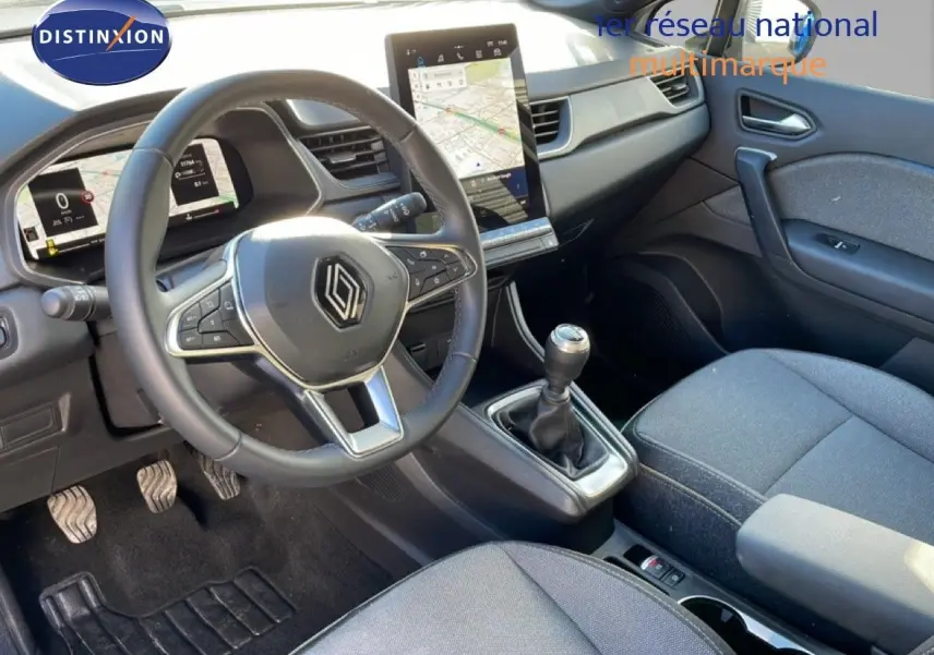 Vue intérieure côté conducteur du Renault Captur 2025 gris rafale avec volant multifonction et écran tactile vertical.