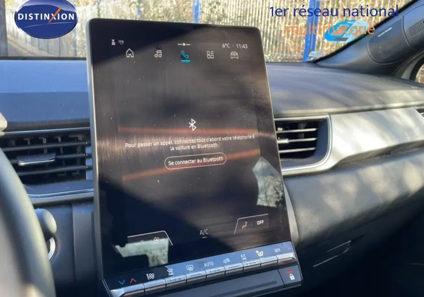 Vue intérieure centrée sur l’écran tactile vertical du tableau de bord du Renault Captur gris Rafale toit noir.