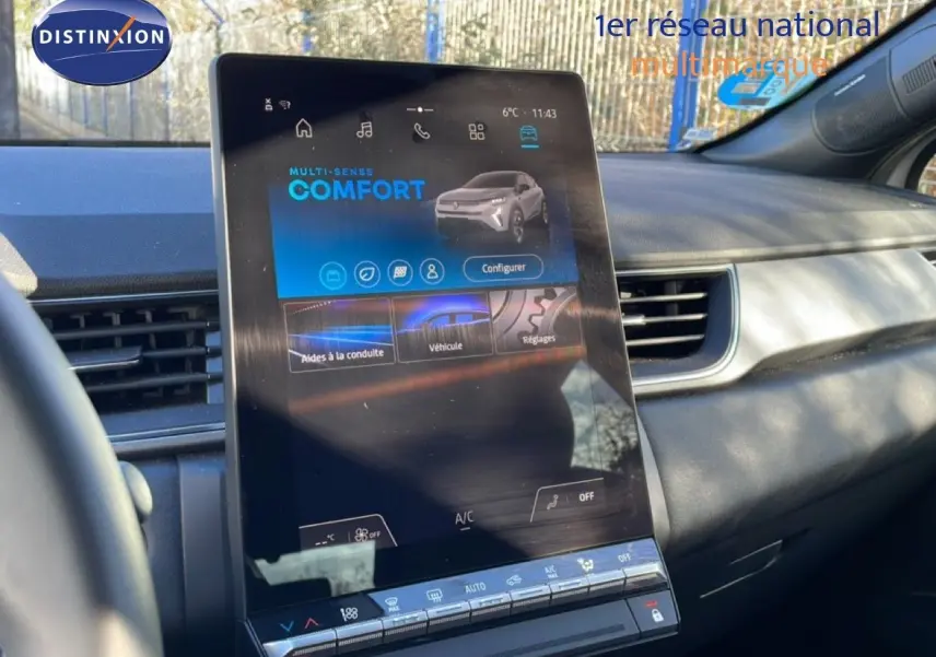 Vue intérieure centrée sur l'écran tactile vertical du tableau de bord du Renault Captur gris Rafale toit noir.
