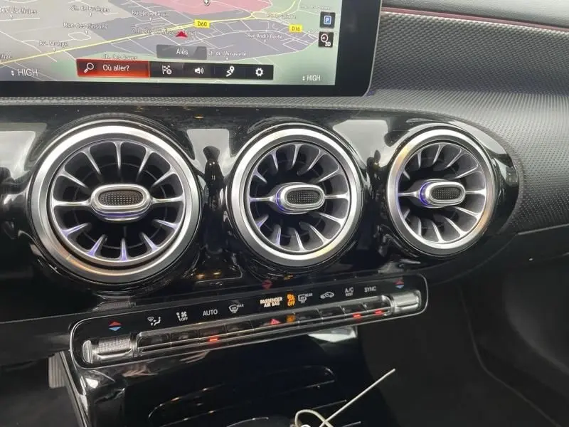 Vue rapprochée des trois aérateurs ronds chromés et de la console centrale noire brillante d’une Mercedes Classe A gris foncé 2019.