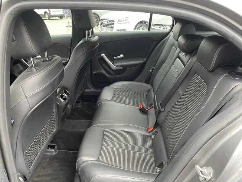 Vue intérieure côté droit sur la banquette arrière en cuir noir d’une Mercedes Classe A gris foncé métal 2019.
