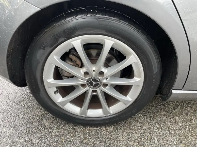 Gros plan sur la roue avant droite d'une Mercedes Classe A 200 gris foncé métal avec jante alliage à dix branches.