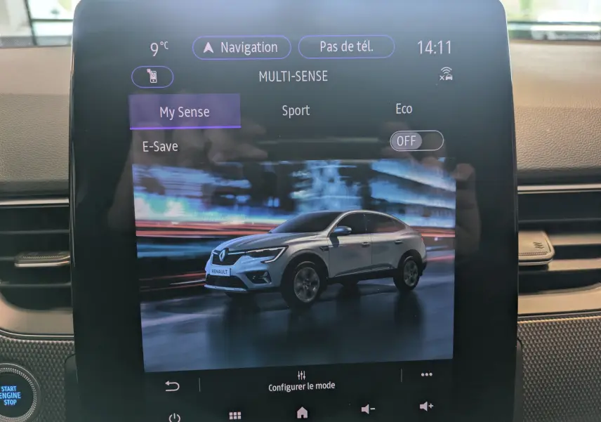 Écran tactile intérieur montrant une Renault Arkana blanche en vue 3/4 avant avec options de mode de conduite.