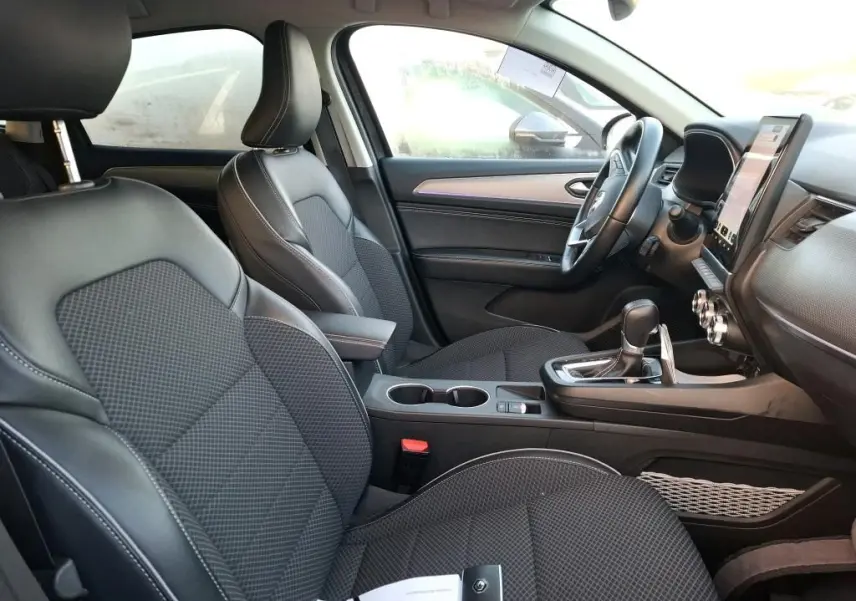 Intérieur avant droit du Renault Arkana 1.6 E-Tech hybride 2023 avec sièges noirs, console centrale et écran tactile vertical.