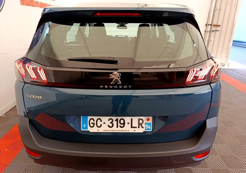 Vue arrière d’un Peugeot 5008 bleu 2021 avec feux LED caractéristiques et logo lion central sur hayon noir.