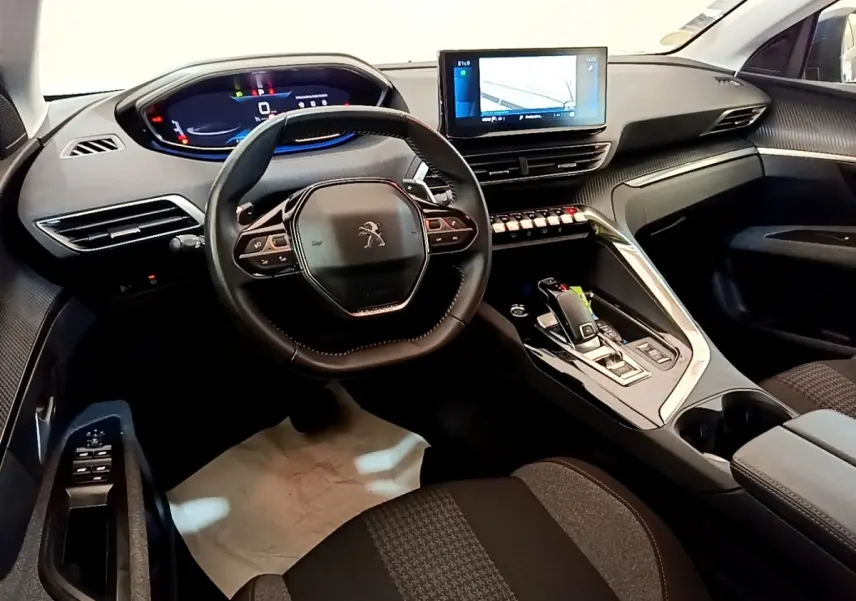 Vue intérieure avant du Peugeot 5008 2021, volant cuir multifonctions et écran tactile central allumé.