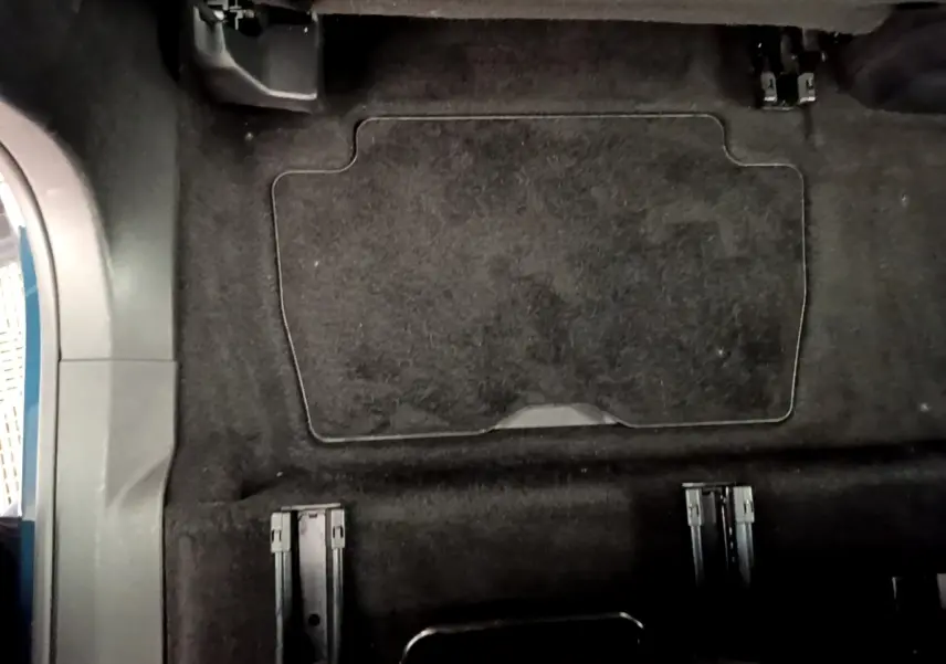 Vue intérieure du plancher arrière noir du Peugeot 5008 2021 sans sièges, montrant les rails d'ancrage des sièges amovibles.