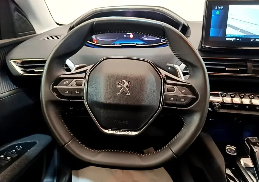 Volant cuir multifonctions Peugeot 5008 2021 vu de face avec tableau de bord numérique et écran tactile bleu.