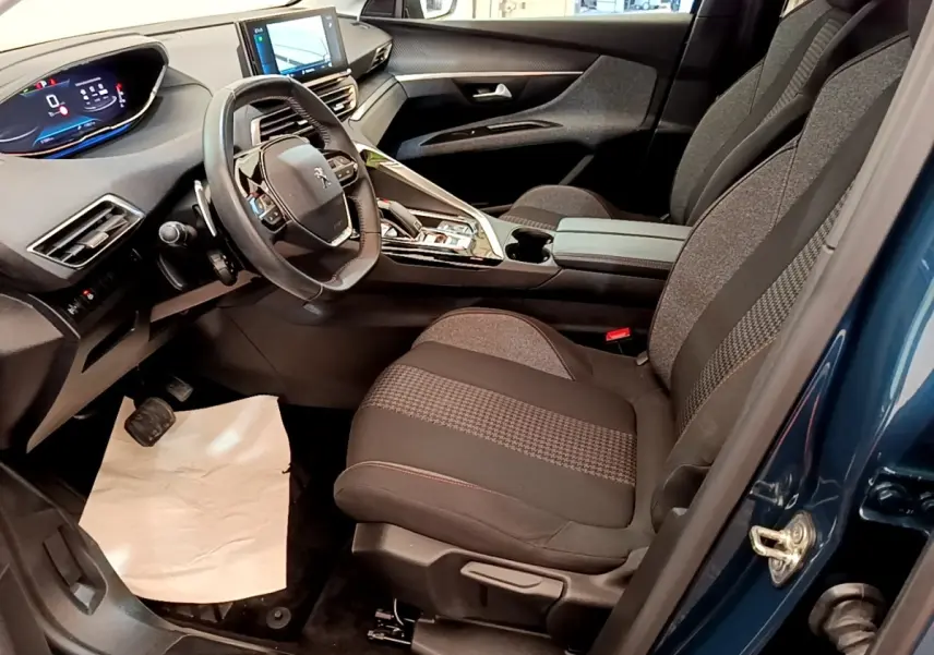 Vue intérieure côté conducteur du Peugeot 5008 bleu 2021, volant cuir multifonctions et tableau de bord numérique.