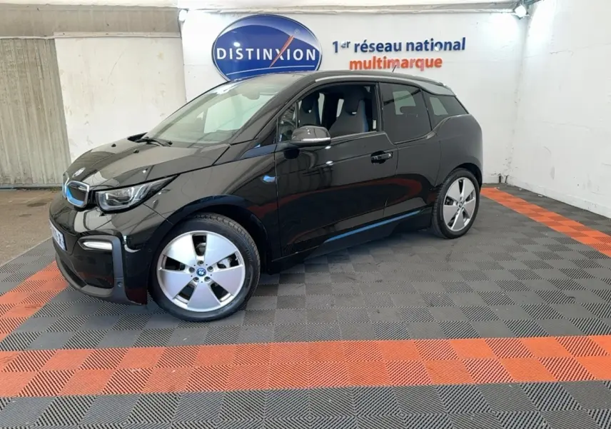 BMW i3 120 Ah noir vue 3/4 avant droit, avec jantes spécifiques et logo bleu électrique sur calandre.