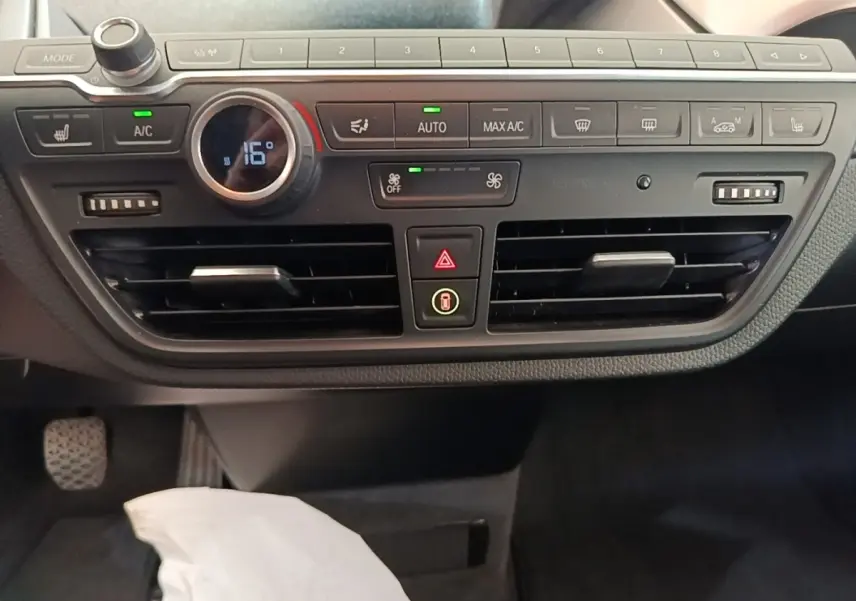 Vue rapprochée du tableau de bord noir de la BMW i3 120 Ah 2020, avec commandes climatisation et ventilation visibles.