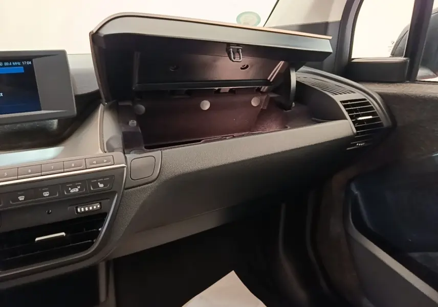 Intérieur de la BMW i3 120 Ah noir, vue côté passager avec boîte à gants ouverte et tableau de bord moderne.