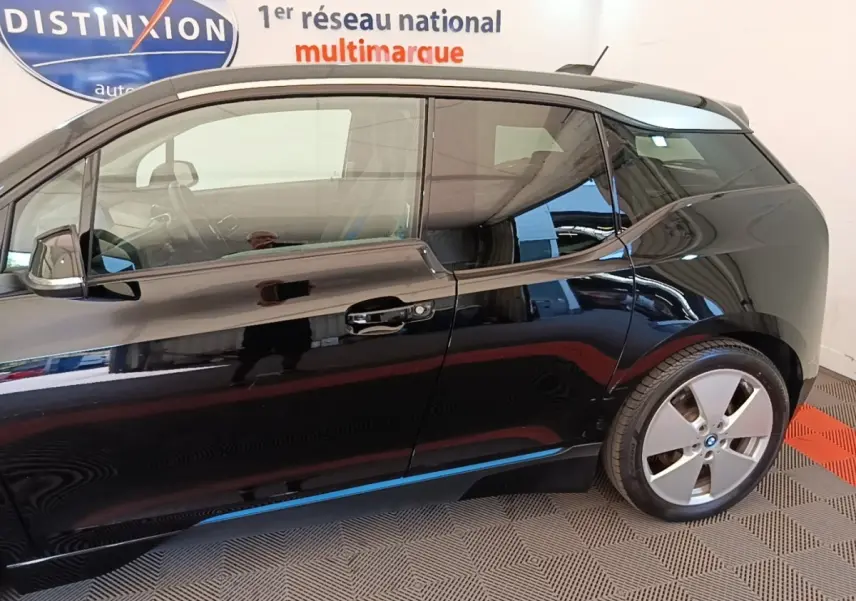 Profil côté droit d'une BMW i3 120 Ah noire, mettant en valeur sa silhouette compacte et ses jantes distinctives.