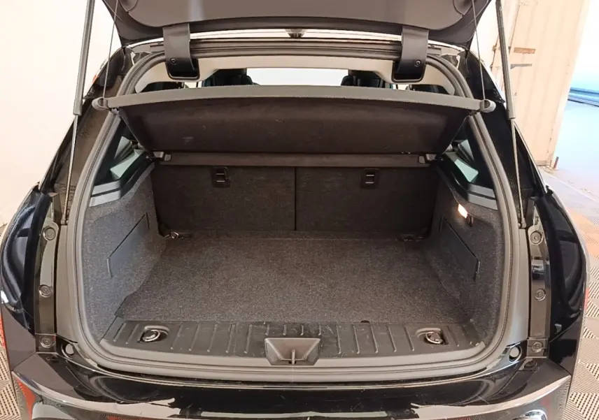 Coffre ouvert d’une BMW i3 120 Ah noire vue de l’arrière, montrant l’espace de chargement et la tablette de séparation.