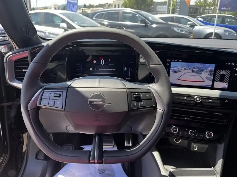 Vue centrée sur le volant noir de l’Opel Mokka Electric 156 GS 2025, avec tableau de bord numérique et écran multimédia.