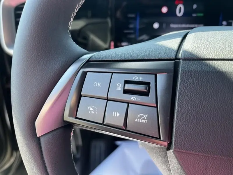 Gros plan sur les commandes au volant à gauche de l’Opel Mokka Electric 156 GS 2025, avec boutons de régulateur et assistance.