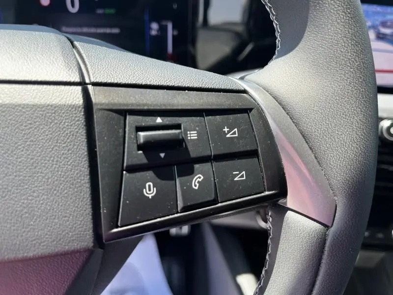 Gros plan sur les commandes au volant côté gauche de l’Opel Mokka Electric 156 GS 2025 noir, avec boutons de volume et téléphone.