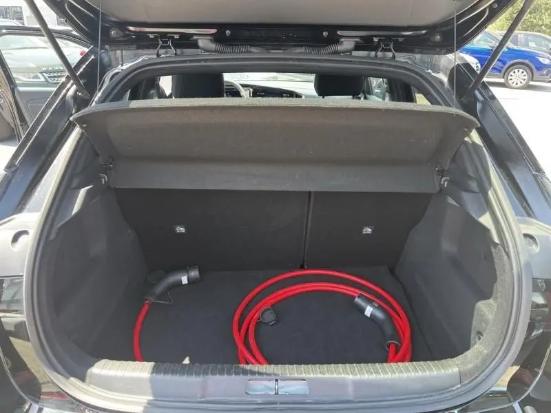 Coffre ouvert d’un Opel Mokka Electric 156 GS noir 2025, vue arrière avec câble de recharge rouge visible.