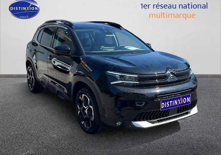 Citroën C5 Aircross noir en 3/4 avant droit avec barres de toit et jantes alu 18 pouces visibles.