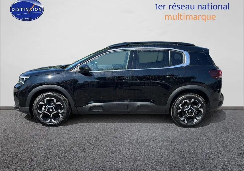Profil côté gauche du SUV Citroën C5 Aircross noir avec jantes alu 18 pouces et barres de toit noires.