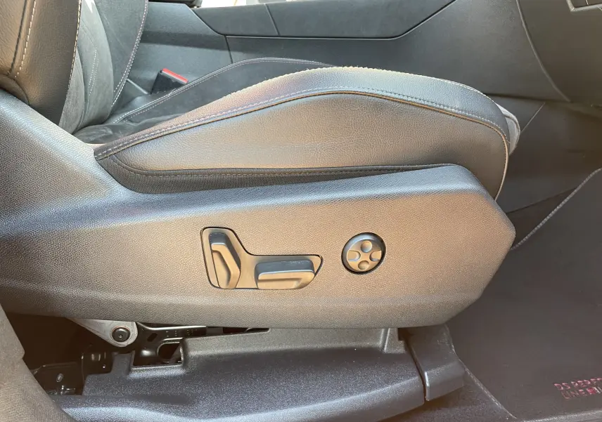 Détail des commandes de réglage électrique du siège avant gauche en cuir noir dans un DS7 gris Artens 2018.
