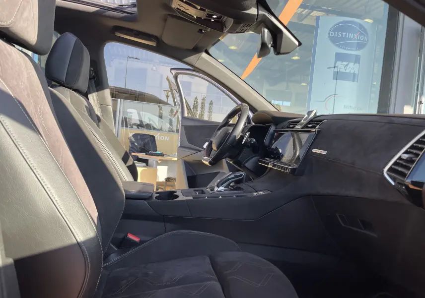 Intérieur côté conducteur du DS7 gris Artens 2018, avec sièges en cuir et alcantara, tableau de bord moderne et toit ouvrant panoramique.