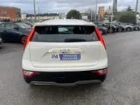 Vue arrière d'un KIA Niro EV 204 CV Active blanc 2024, avec feux arrière en forme de L et plaque d'immatriculation visible.