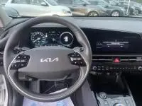 Vue intérieure du tableau de bord et volant du KIA Niro EV blanc 2024, version Active avec écran tactile et commandes au volant.