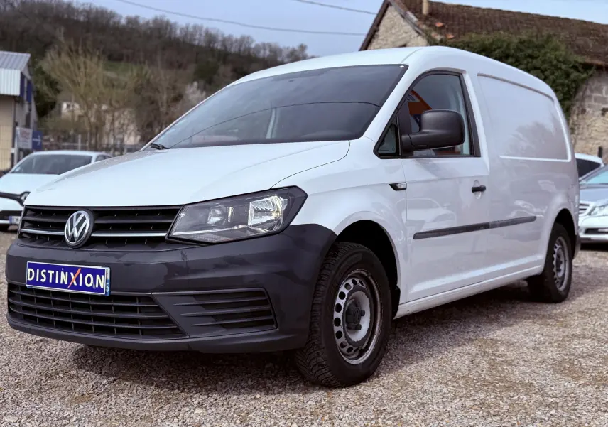 Vue 3/4 avant droit d’un utilitaire Volkswagen Caddy Maxi Long blanc avec pare-chocs noir et jantes acier.