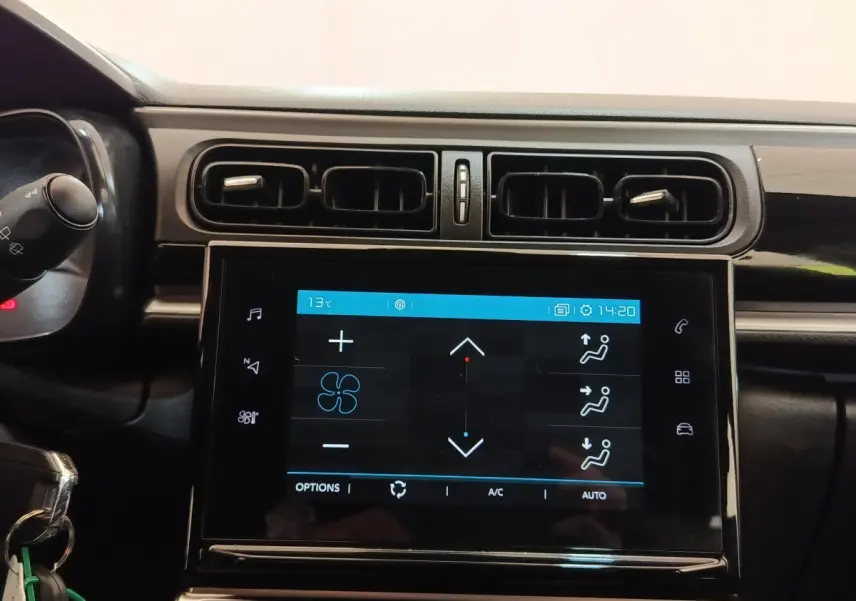 Écran tactile central noir affichant la climatisation, entouré des aérateurs horizontaux du tableau de bord d'une Citroën C3.