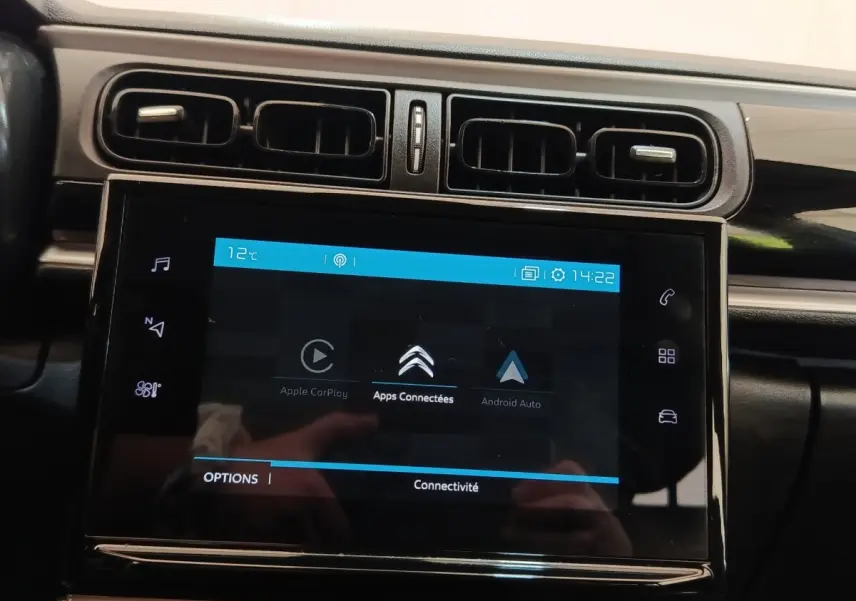 Vue rapprochée de l’écran tactile central noir affichant les options Apple CarPlay et Android Auto dans une Citroën C3 blanche.