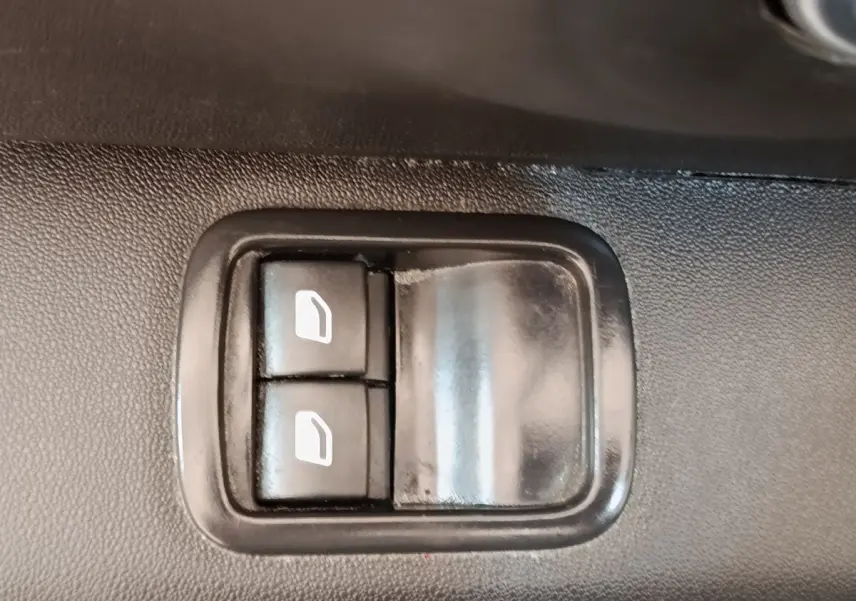 Boutons de commande des vitres électriques sur la porte intérieure d'une Citroën C3 blanche, version PureTech 83 S&S BVM Feel Nav.