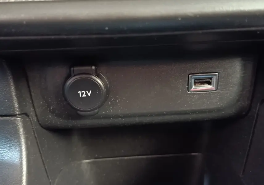 Prise 12V et port USB intégrés dans la console centrale noire d'une Citroën C3 blanche.