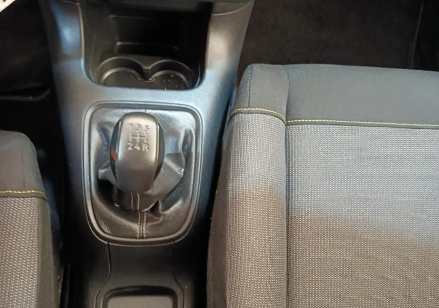 Vue intérieure centrée sur la console centrale et levier de vitesses manuelle d'une Citroën C3 2022 avec sièges gris.
