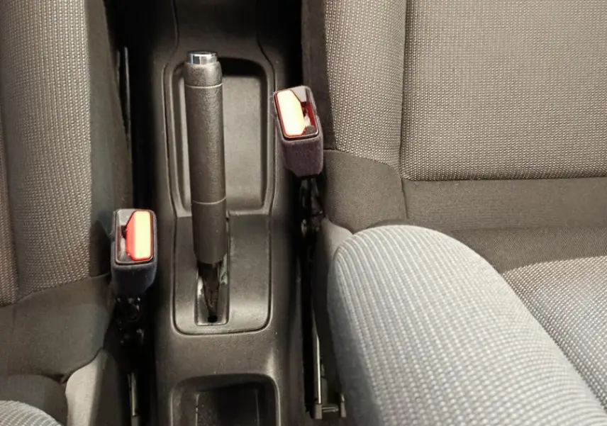 Vue plongeante sur la console centrale et les sièges gris foncé de la Citroën C3 PureTech 2022, avec frein à main manuel.