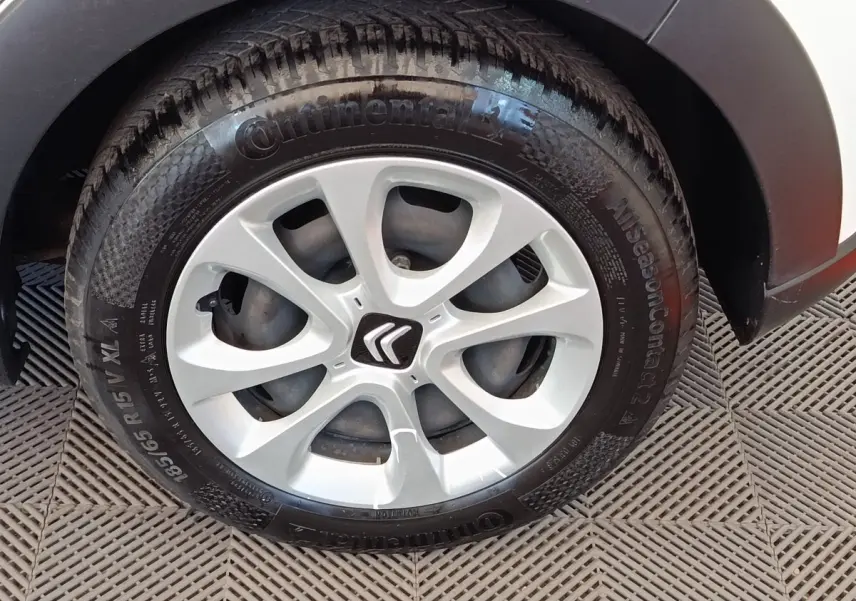 Gros plan sur la roue avant gauche blanche d'une Citroën C3 2022 avec jante argentée et logo Citroën central.