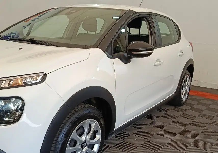 Citroën C3 blanche vue 3/4 avant droit, avec rétroviseur noir et jantes alliage distinctives.