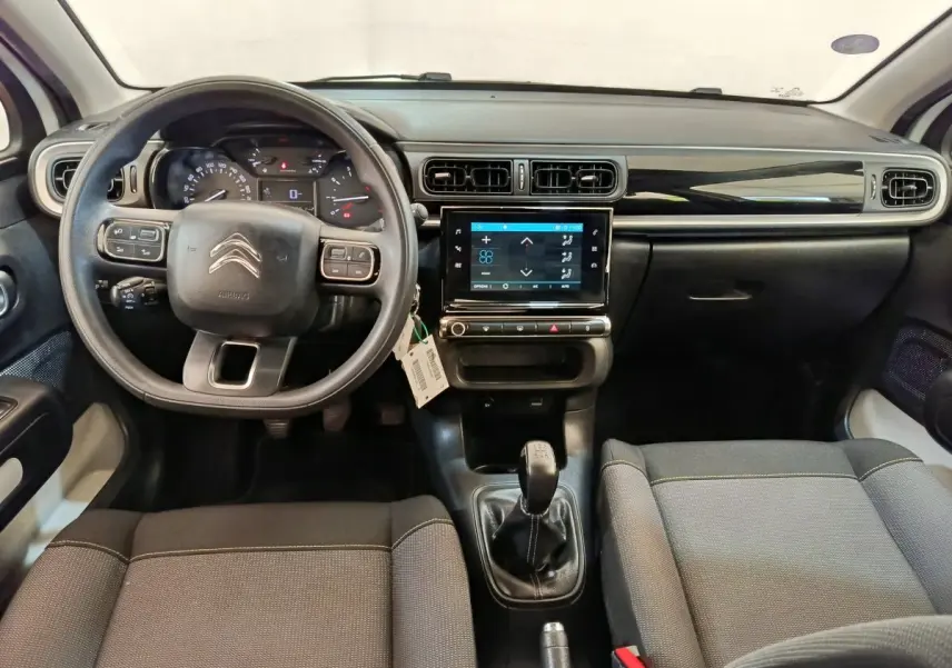 Vue intérieure avant du tableau de bord et volant noir de la Citroën C3 PureTech 83 de 2022 avec écran tactile central.