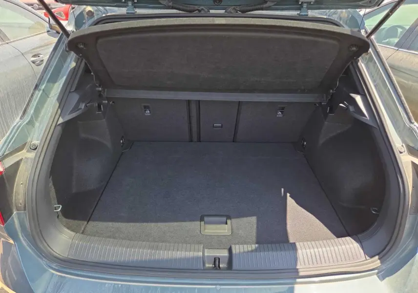 Coffre ouvert vu de l'arrière d'un Volkswagen T-Roc noir métal, montrant un espace de chargement vide et propre.