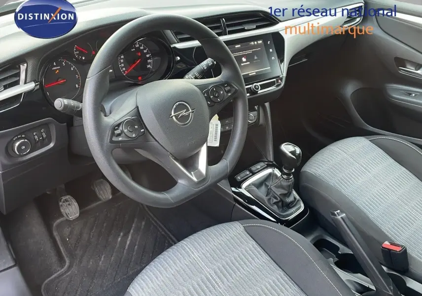 Vue intérieure côté conducteur de l'Opel Corsa gris Kristall Metal, volant multifonction et levier de vitesse manuel visibles.