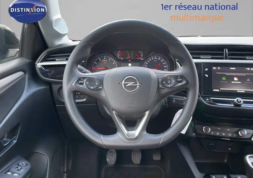 Vue intérieure centrée sur le volant Opel de la Corsa 1.5 Turbo D 102ch, avec tableau de bord et écran tactile visibles.