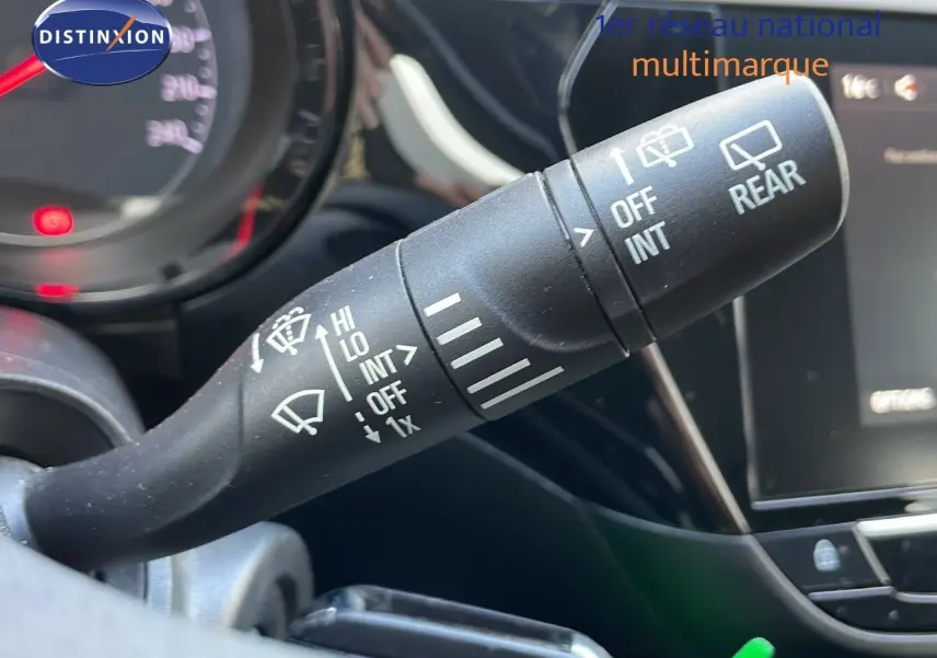 Gros plan sur la commande d’essuie-glace à gauche du volant dans l’habitacle d’une Opel Corsa gris Kristall Metal.