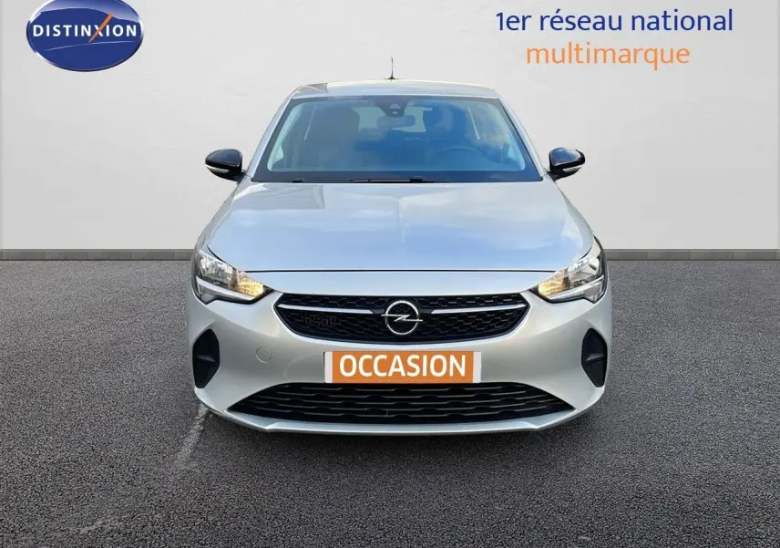 Vue frontale d'une Opel Corsa gris Kristall Metal de 2022 avec calandre noire et phares allumés.