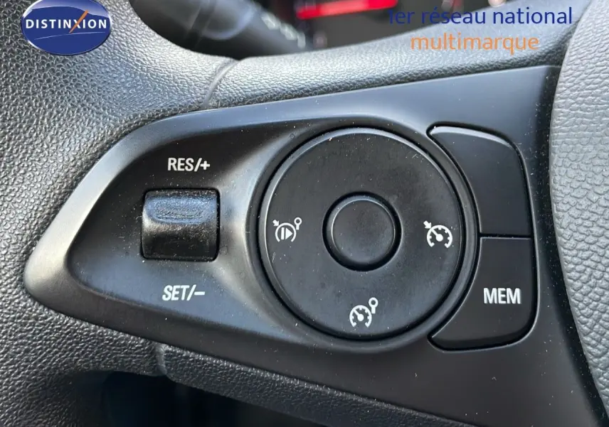 Gros plan sur les commandes de régulateur de vitesse au volant d'une Opel Corsa gris Kristall Metal de 2022.