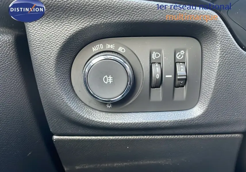 Gros plan sur les commandes d’éclairage intérieures d’une Opel Corsa gris Kristall Metal, tableau de bord noir.