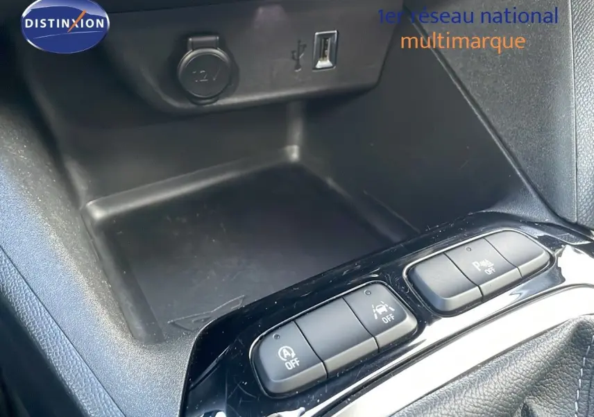 Vue rapprochée de la console centrale noire de l’Opel Corsa gris Kristall Metal, avec boutons de contrôle et prise USB.