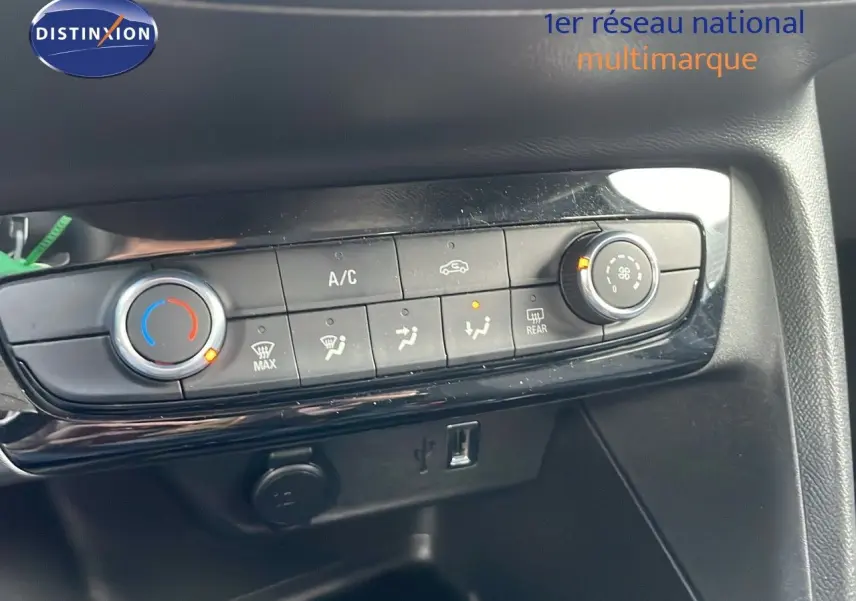 Détail de la console centrale de l’Opel Corsa 2022, montrant les commandes de climatisation et les ports USB et 12V.