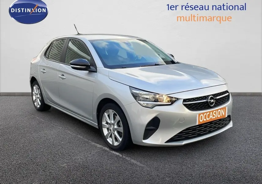Opel Corsa gris kristall metal vue 3/4 avant droit avec phares allumés sur fond neutre.